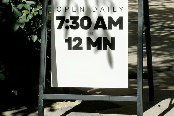 The same shop sign with opening time changed to 7:30 AM
