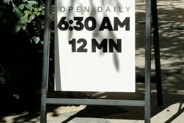 Shop sign showing opening time of 6:30 AM