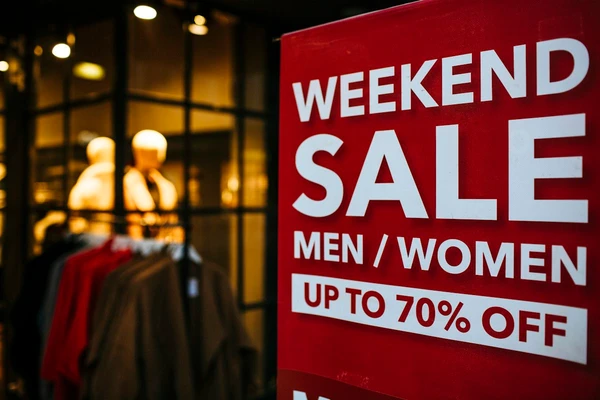 Real shop-window promotion reading WEEKEND SALE and UP TO 70% OFF